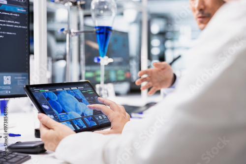 Принти на полотні Close up of clinical laboratory technologist looking at 3D molecular model on tablet