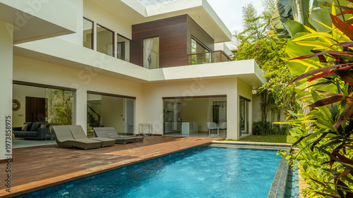 A large house with a pool and a garden. The house is white and has a lot of windows
