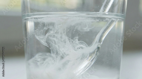 A glass of water with a spoon in it