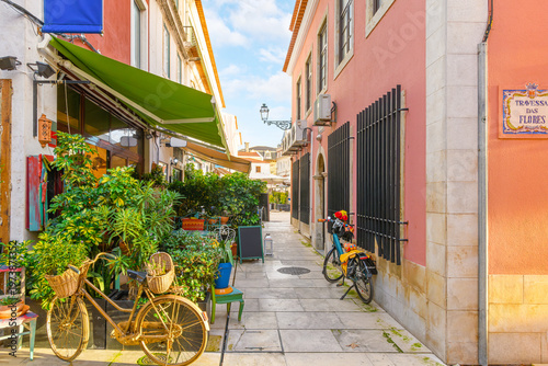 Photography A narrow, colorful pedestrian street full of sidewalk cafes, shops and markets in the historic old town center of Cascais, Portugal, on the Portuguese Riviera