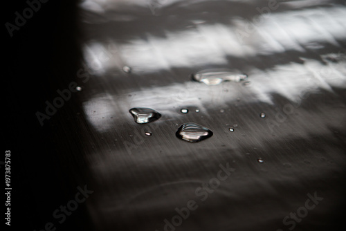Macro Shot of Clear Water Drops on Dark Reflective Surface