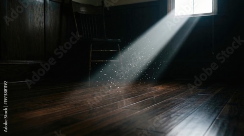 Bright sunlight beam with floating dust particles illuminates dark wooden floor in old, quiet room.