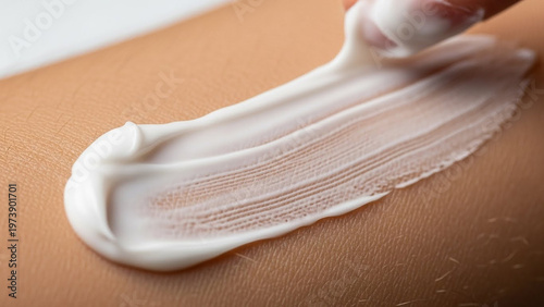 Close-up of white cream being applied to human skin for moisturizing and skincare purposes.