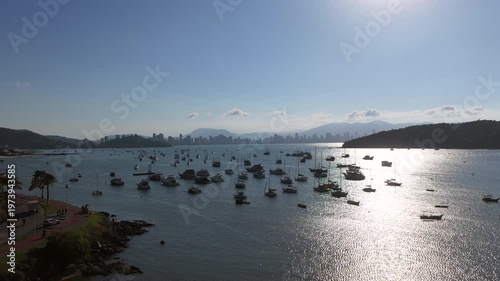 Aerial view of Porto Belo bay with anchored boats and Itapema skyline at sunset in Santa Catarina.