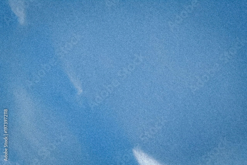 Dreamy blue sky scene with soft drifting clouds and fine grain texture adds a tranquil, airy feel, perfect for inspirational designs, posters, and calming web headers.