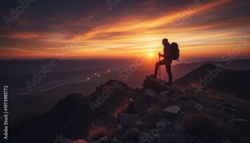 Hiker stands on mountain peak at sunset with stunning sky.