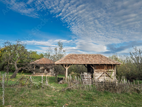 Tableau sur toile Abandoned farm buildings in the Serbian countryside, with weathered wooden sheds, old fencing and overgrown grass