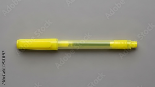 Vibrant yellow highlighter on a grey background, minimalist composition