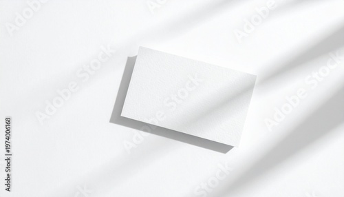 Minimalist overhead view of a blank white square card casting a soft shadow, ideal for product mockups and design presentations