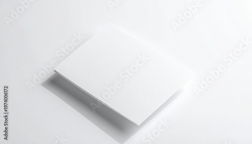 Blank white booklet or brochure standing on a white surface, casting a shadow, perfect for design mockups and presentations