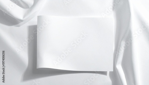 Blank white square brochure or booklet mockup on a soft draped fabric. Perfect for elegant branding, portfolio presentation, or product display with a clean, minimalist aesthetic