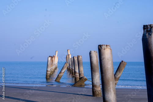 The Leaning pole at Sao Aiang Beach- Derelict concrete pier posts in the seaOld concrete pillars from an abandoned fishing pier, sticking out of the sea