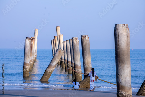 The Leaning pole at Sao Aiang Beach- Derelict concrete pier posts in the seaOld concrete pillars from an abandoned fishing pier, sticking out of the sea