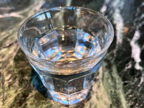 大理石模様のテーブル上の水が入ったグラス