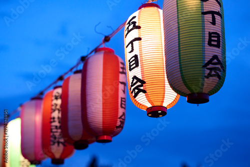 夏祭りの提灯が並ぶ夕暮れの空