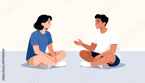 Two people sit cross-legged, facing each other. Their expressions suggest calm conversation or friendly chat. Soft lighting creates a gentle, intimate atmosphere. Ideal for illustrating connection