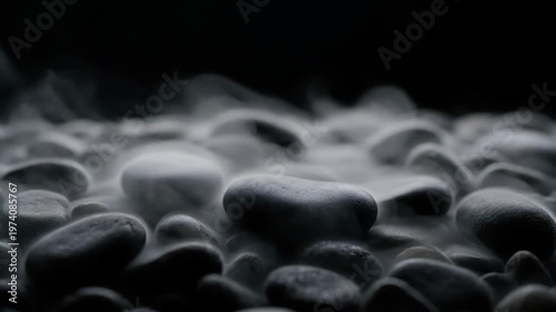 Mysterious Dry Ice Smoke Billowing Over Dark River Rocks in a Low Light Setting.