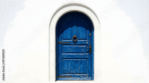 Traditional blue arched wooden door on a white wall in Santorini Greece Mediterranean style architecture with weathered texture and vintage handle