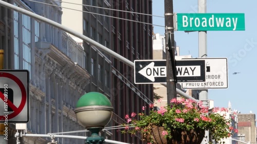 New York City Broadway street sign in Manhattan Midtown, United States. Urban road sign, traffic sign. Building architecture in Flatiron district. Crossroad with 5 fifth avenue. Subway metro lamp.