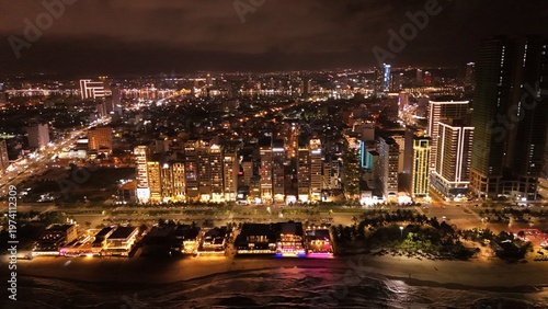 Vászonkép Da Nang City, Vietnam: 4K aerial drone footage of night skyline, illuminated bridges, riverfront, city lights, urban landscape and waterfront reflections
