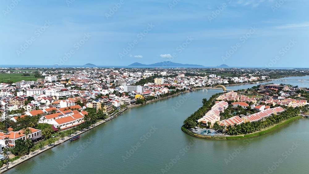 Fototapeta premium Hoi An (Hoian), Da Nang City (Quang Nam), Vietnam: 4K aerial view of ancient town, UNESCO heritage, Hoai river, boats, lantern streets and historic waterfront.