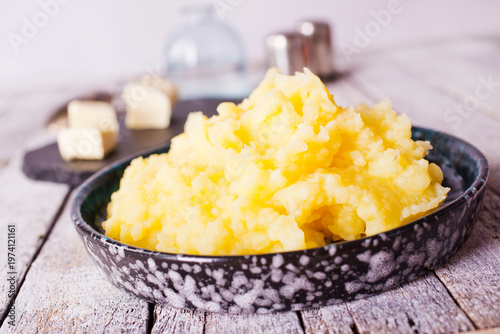 Mashed potatoes in bowl on a wooden background