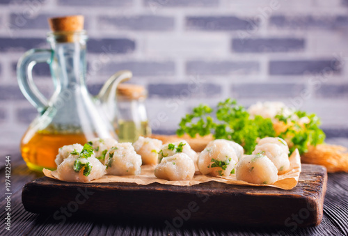raw chicken balls on wooden board