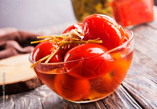 Assortie Jars of Marinated vegetables picles tomato on a wooden background