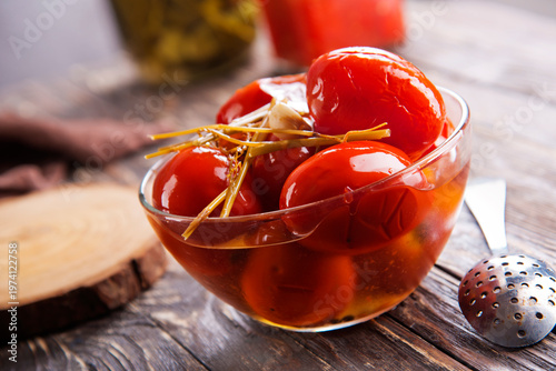 Assortie Jars of Marinated vegetables picles tomato on a wooden background