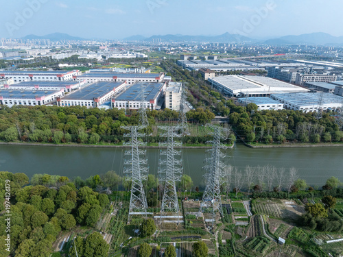 Принти на полотні Industrial zone with high-voltage transmission towers alongside river and farmla