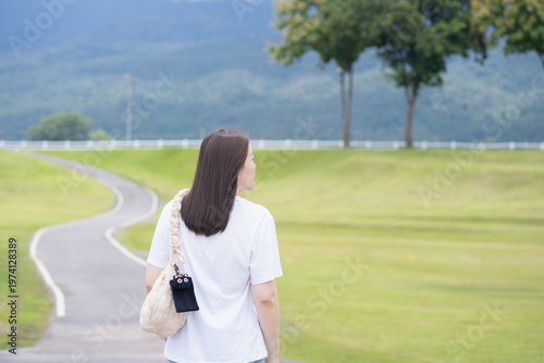 Relax and wellness concept with woman walk on road in garden and mountain background at chiangmai thailand in raining season
