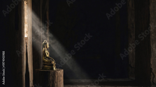 Golden Buddha Statue with Divine Light Beam in Dark Temple - Spiritual Enlightenment, Hope, and Zen Meditation Concept