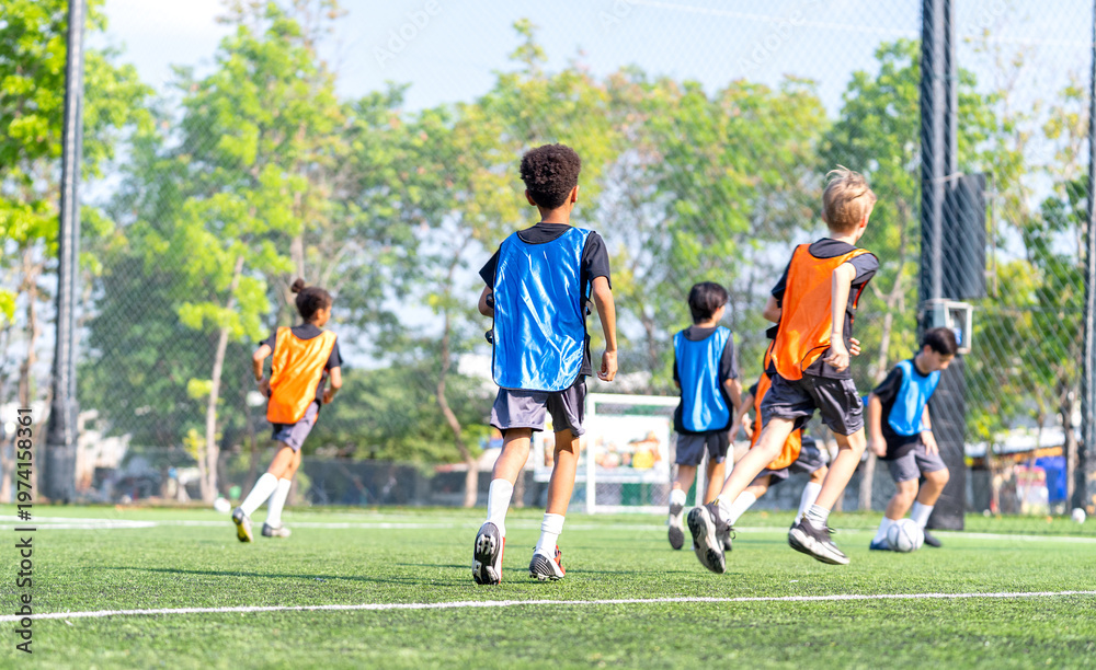 Obraz premium Group of boys and girls enjoy to practice to play soccer together in the field with day light and they look happy to exercise to get good health.