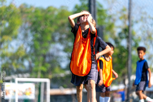 Photography A little boy with orange team action or express of sad after miss of kick-out the goal or lost the ball to the competitor