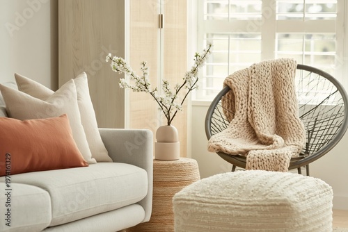 Cozy living room with a sofa, armchair and knit blanket on a sunny day