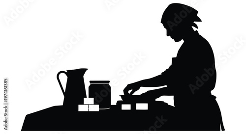 A woman preparing food at a table depicted in stark contrast silhouette