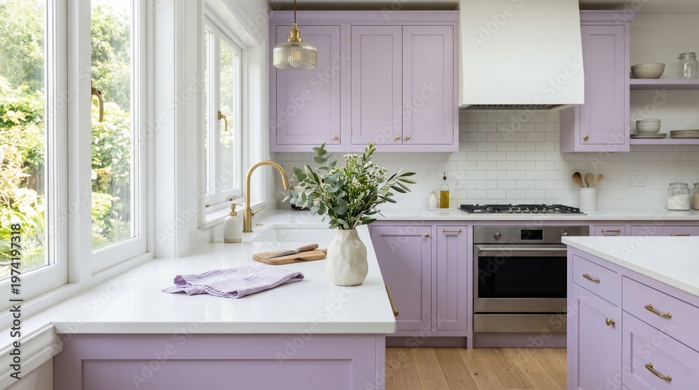 Fototapeta premium A serene kitchen interior with lilac cabinets and a white island featuring a vase and towels near a sunny window.