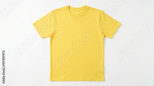 A bright yellow t-shirt lies flat on a clean white surface indoors.