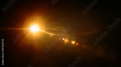 A powerful golden light source shines brilliantly through a dark void, producing an elongated lens flare effect with multiple shimmering reflections and streaking light.