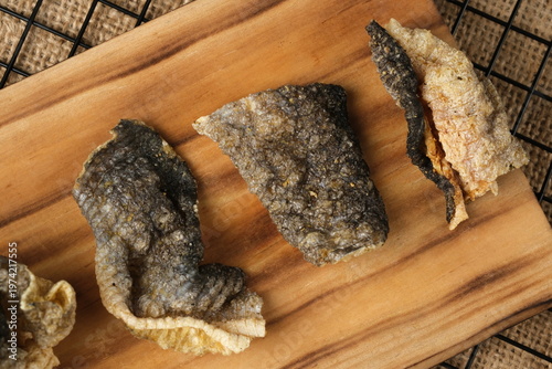 Crispy salmon skin snacks on a wooden board  burlap. Perfect for food blogs, restaurant menus, seafood advertisements, or culinary websites.