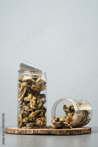 Two jars full of salmon fish skin chips snacks ideal for seafood snack branding, innovative snack packaging, and fish skin product ads.