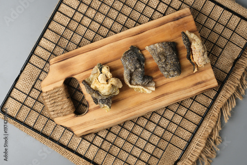 Crispy salmon skin snacks on a wooden board  burlap. Perfect for food blogs, restaurant menus, seafood advertisements, or culinary websites.