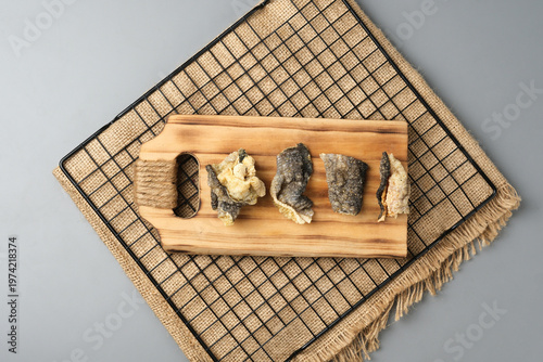 Crispy salmon skin snacks on a wooden board  burlap. Perfect for food blogs, restaurant menus, seafood advertisements, or culinary websites.