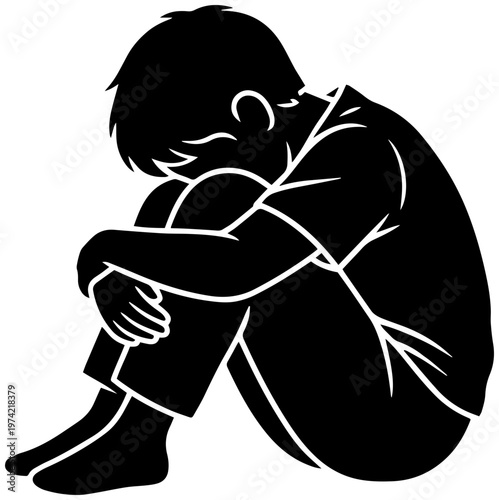 Sad child sitting alone in distress looking down