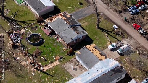 Aerial Footage from drone of residential neighborhood destruction after a tornado with damaged houses and scattered debris.
