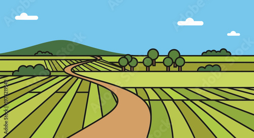 Winding dirt road through green agricultural fields under a blue sky with clouds