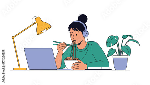 Young woman wearing headphones and eating noodles while working diligently on her laptop late at night at her office desk.