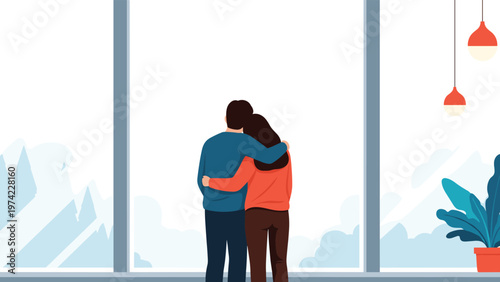 Happy couple seen from behind standing by a large floor to ceiling window looking out at a scenic landscape of snowy mountains and clouds.