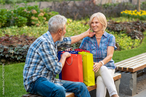 Happy senior couple with shopping bags after shopping