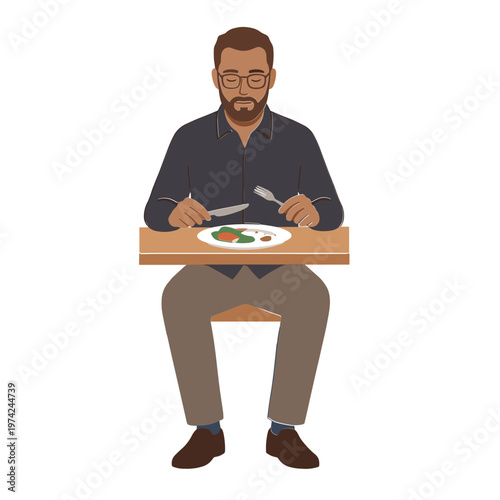 Man sitting at table eating food with knife and fork indoors